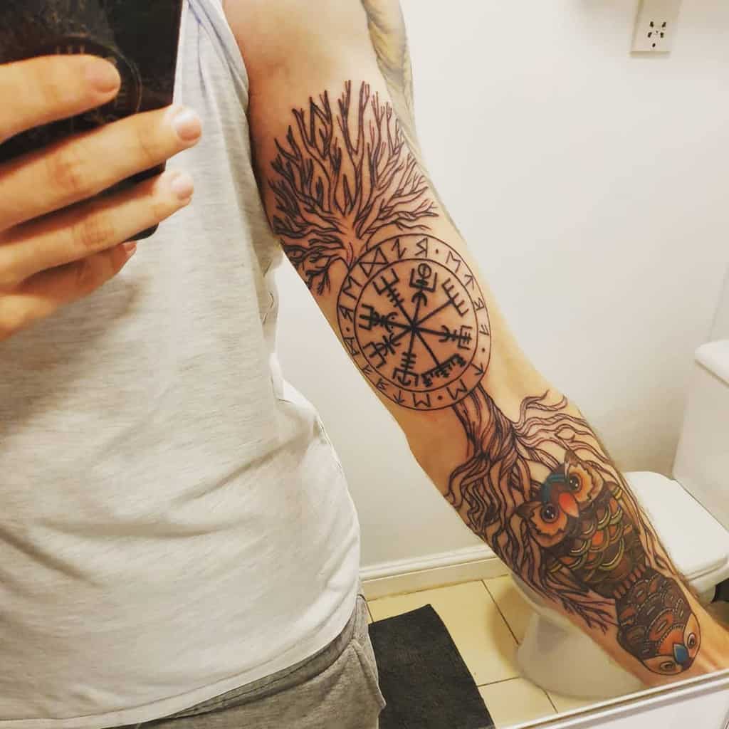 The tattoo features Yggdrasil with a Vegvisir symbol on the trunk and an owl on the roots, blending Norse mythology with wisdom and guidance.