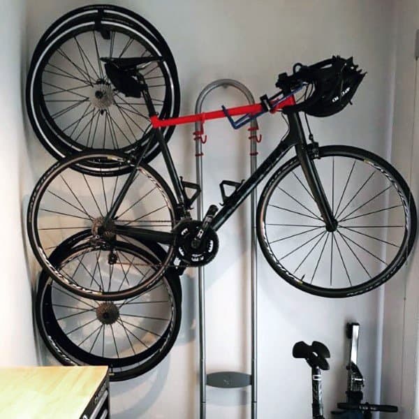 Compact bike garage with vertical wheel racks, a mounted bike, and organized helmet storage for a neat space.
