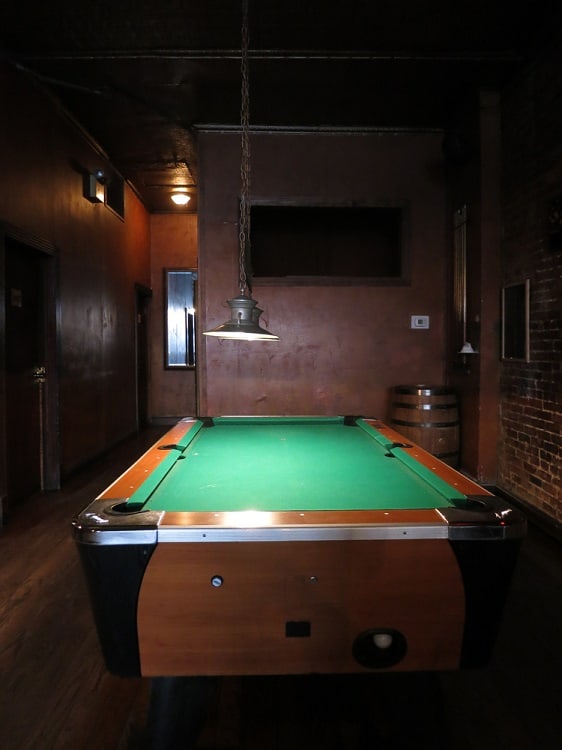 small room billiard table pendant lighting brick wall 