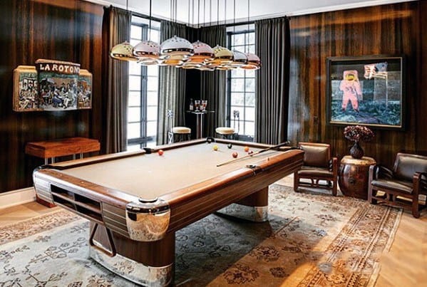 Art Deco billiard room with a vintage pool table, wood paneling, and colorful pendant lights.