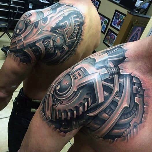 Man showcasing intricate biomechanical tattoos on upper arm and shoulder