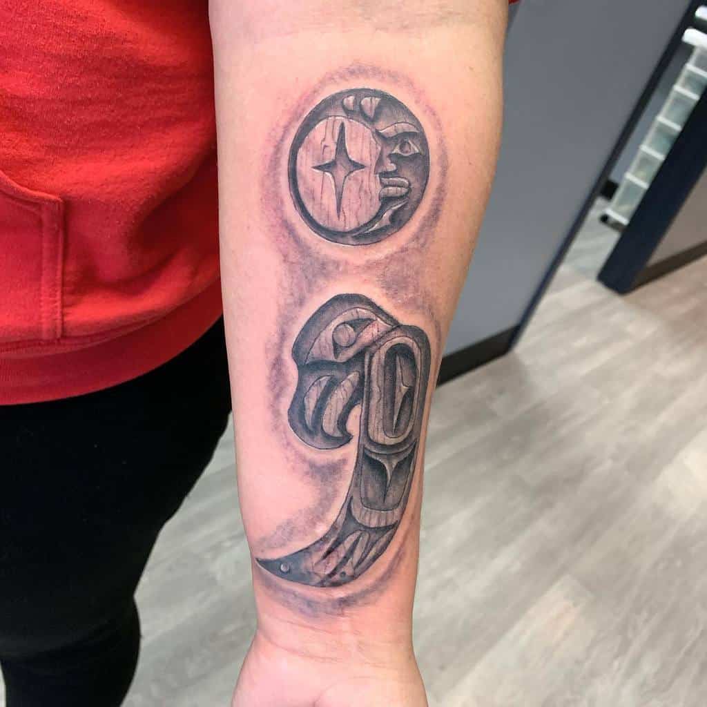 The tattoo showcases a detailed design featuring a crescent moon-like shape with stars above, and a large, abstract semicolon at the bottom. The shading adds depth and intricacy to the tattoo.