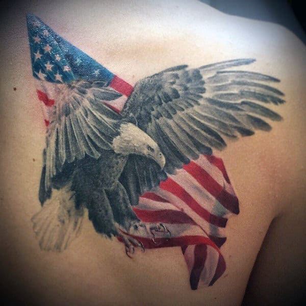 Tattoo of an eagle flying with an American flag behind it, on a person's upper back