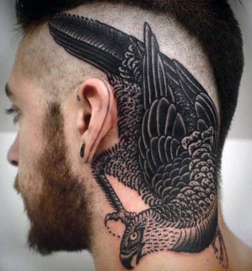 A detailed eagle tattoo on the side of a person's head and neck with a shaved hairstyle
