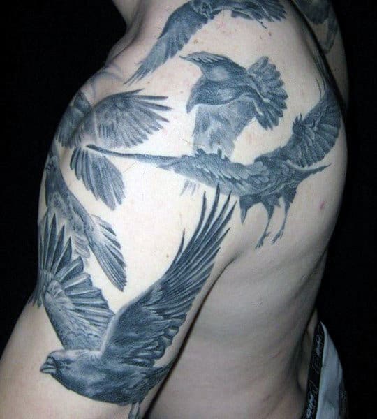 Tattoo of flying birds on upper arm and shoulder