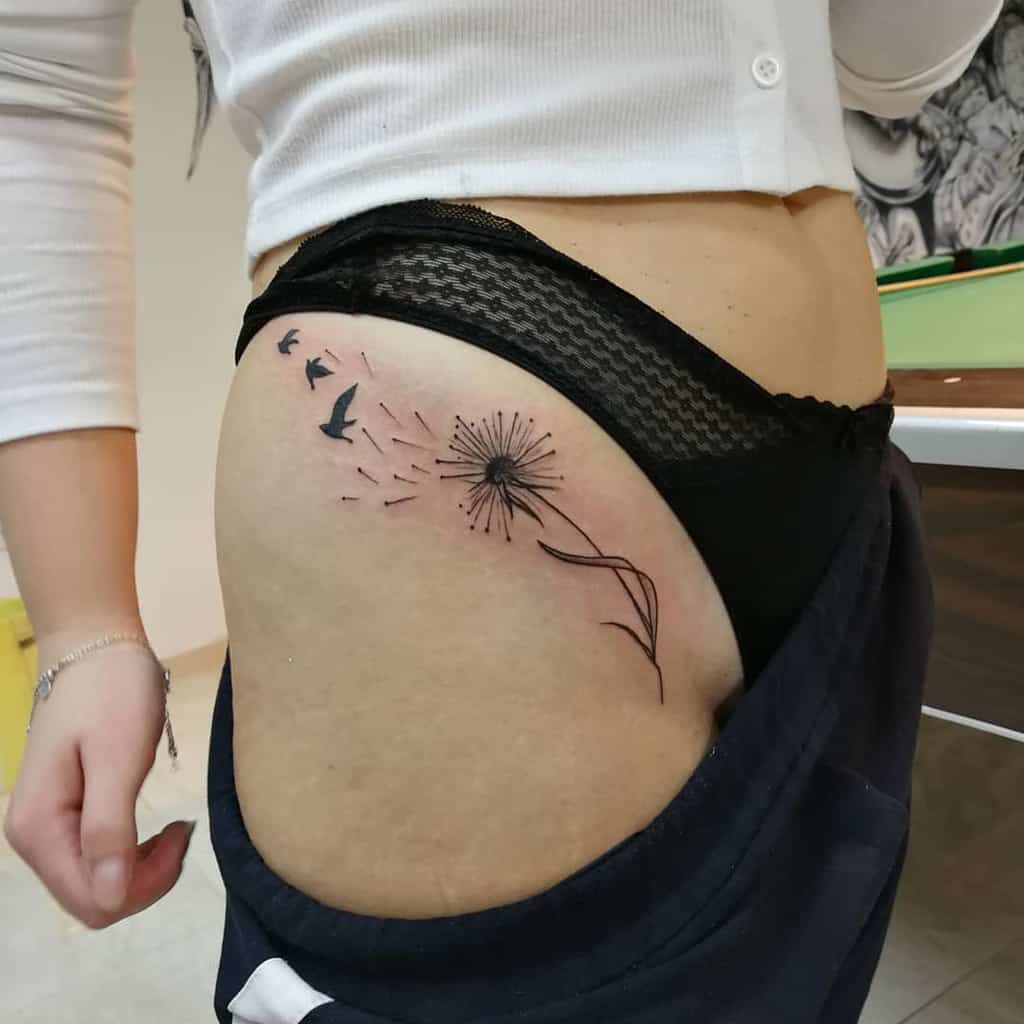 This tattoo features a dandelion, with seeds floating away and transforming into birds, symbolizing freedom and new beginnings.