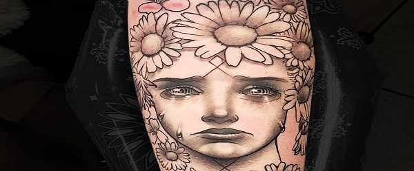 Forearm tattoo large surreal black and grey crying May Queen framed by daisies