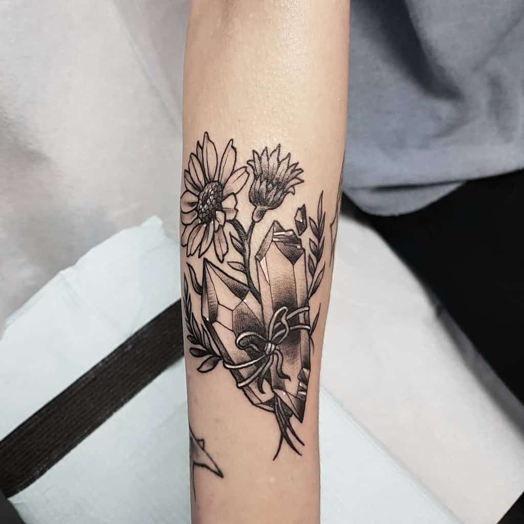 Forearm tattoo black and grey daisies and crystals