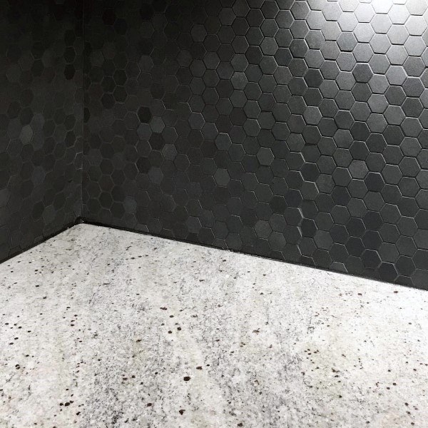Black hexagon tile backsplash with speckled granite countertop.
