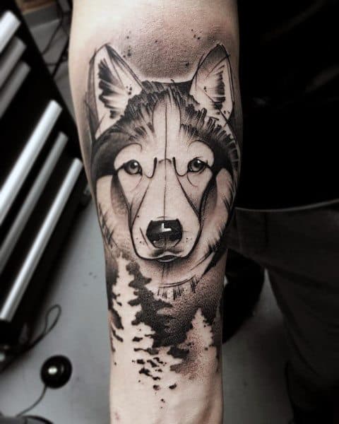 Geometric Siberian Husky tattoo on a man's forearm, featuring fine dot work, bold lines, and a forest silhouette for a modern aesthetic.