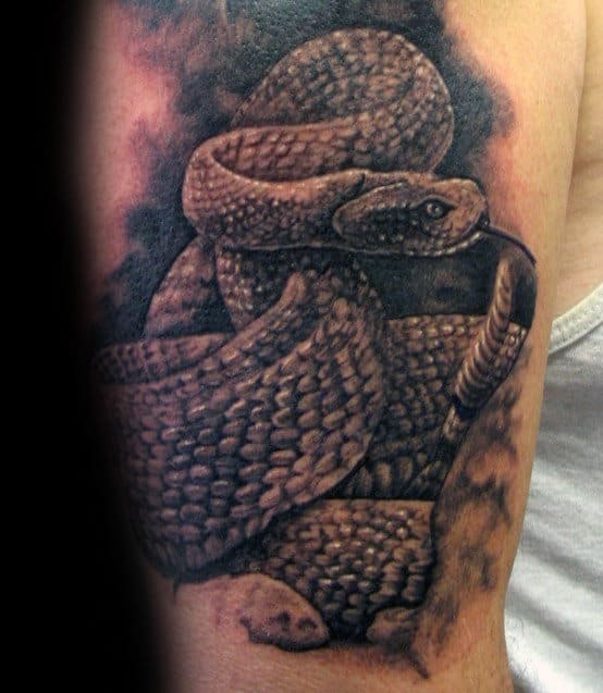Tattoo of a coiled rattlesnake on an arm, with detailed scales and a rattling tail