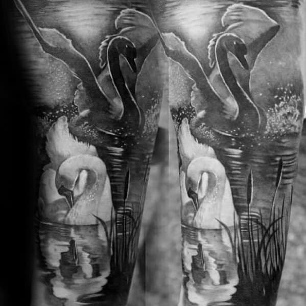 Dual swan tattoo with one in flight and the other gazing at its reflection, set on a serene lake with reeds and moonlit water.