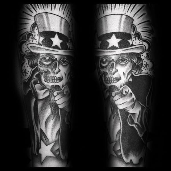 Dark skeleton Uncle Sam tattoo in black and gray, pointing forward with bold shading, starburst background, and eerie hollow eyes.