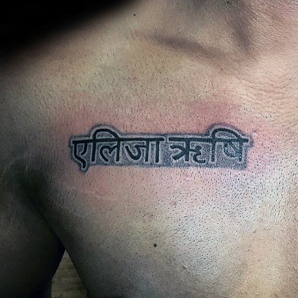 Black And Grey Ink Upper Chest Sanskrit Male Tattoo Designs