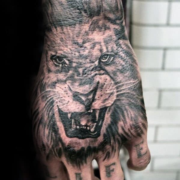 Black And Grey Male Lion Hand Tattoo