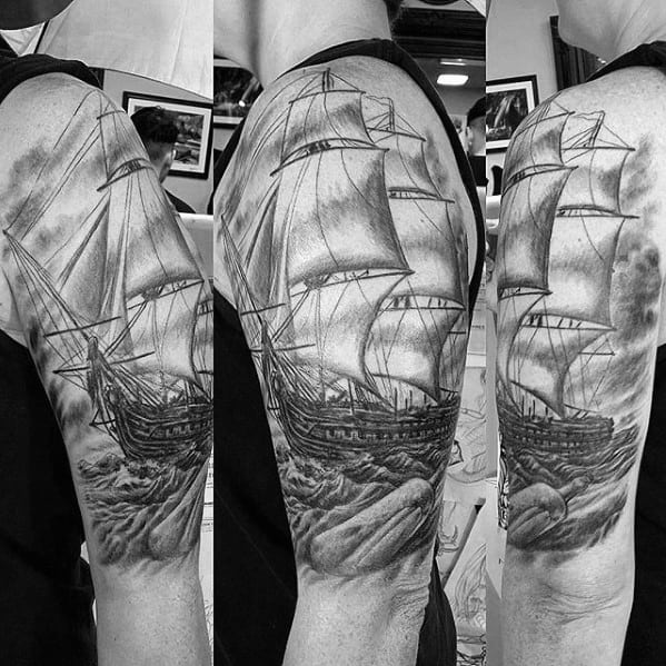 Detailed black-and-gray tattoo of a large sailing ship navigating stormy seas