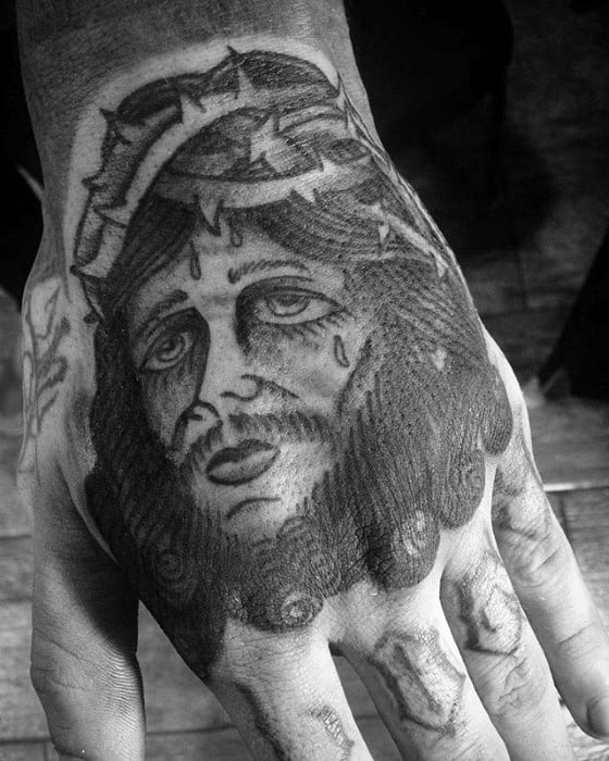 Black And Grey Shaded Traditional Jesus Male Hand Tattoo