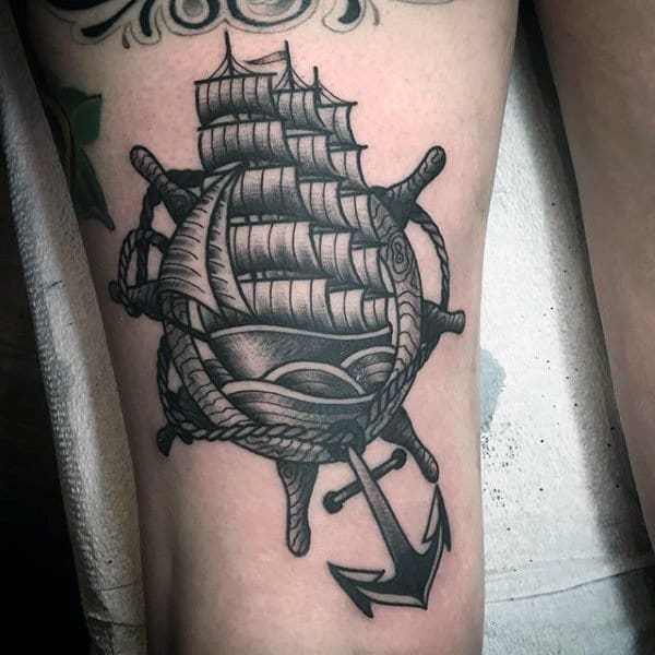 Black And Grey Ship Inside Wheel With Anchor Nautical Tattoo On Male