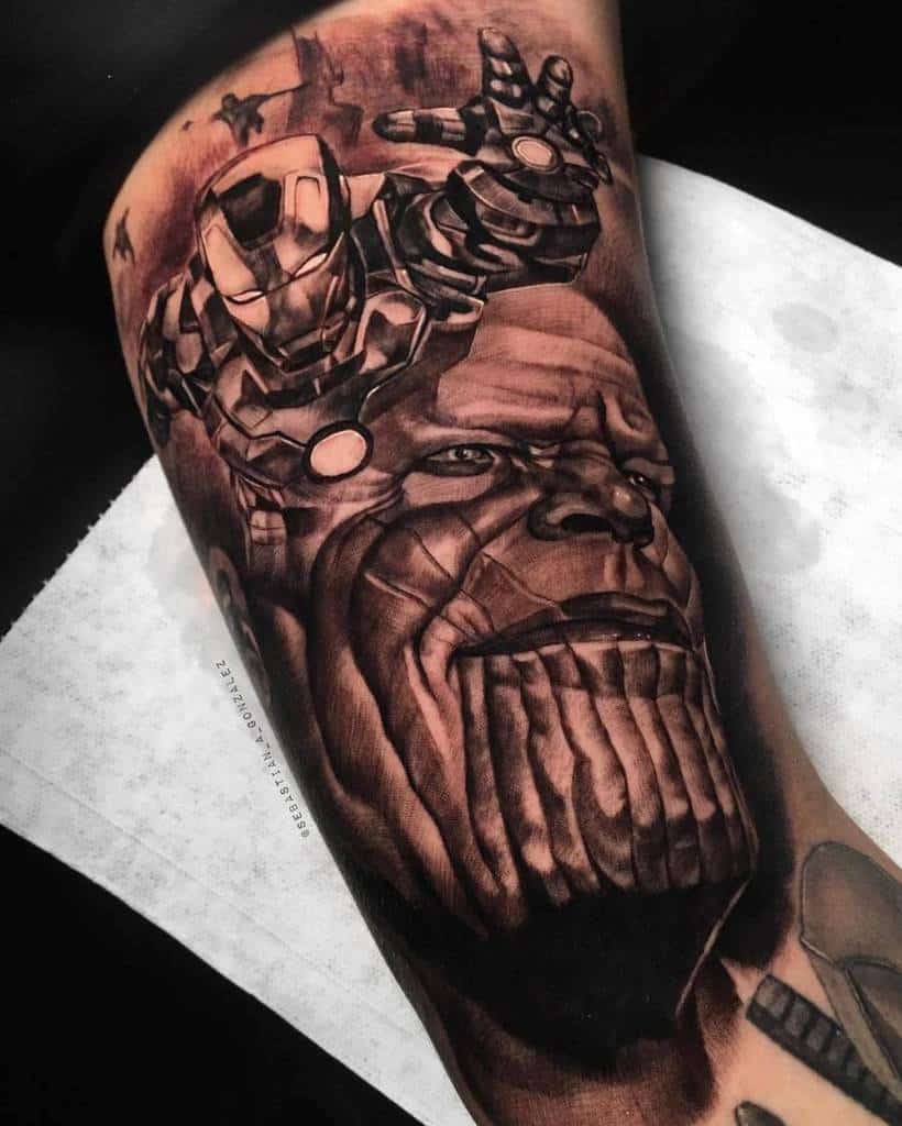 Black and grey tattoo of Thanos with Iron Man reaching forward, detailed shading and realism