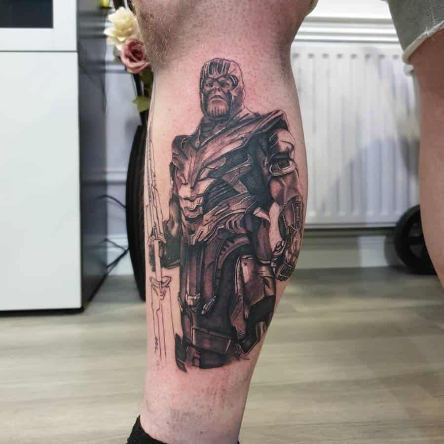 A black and gray tattoo of Thanos in full armor with sword, standing confidently with a detailed expression and intricate shading on his figure