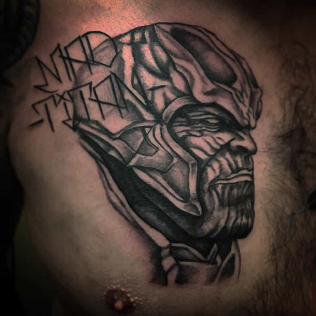 A black and gray tattoo of Thanos in profile, showing his intense expression, with the words "MAD TITAN" stylized beside him