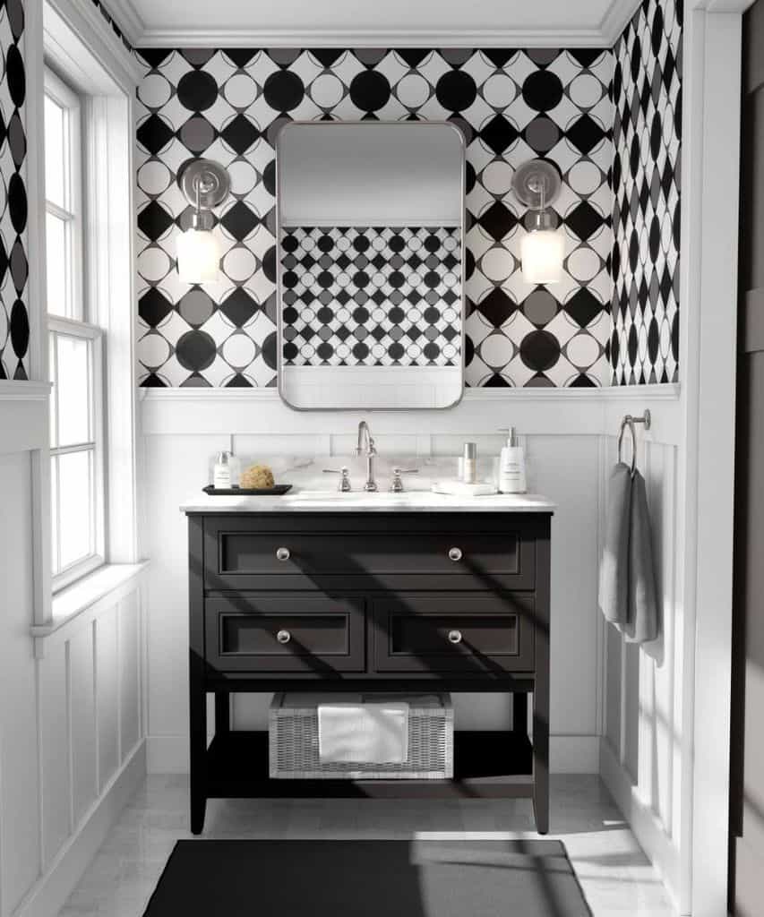 Black and white bathroom with geometric wallpaper, black vanity, and wall sconces.