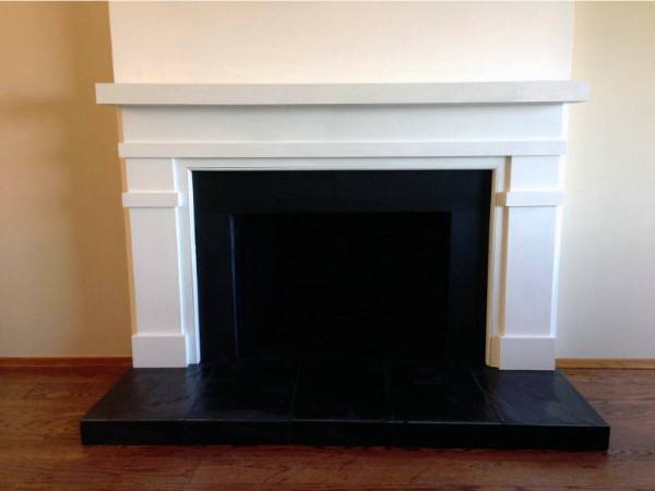 Black and white fireplace mantel with clean lines and a sleek, modern design.