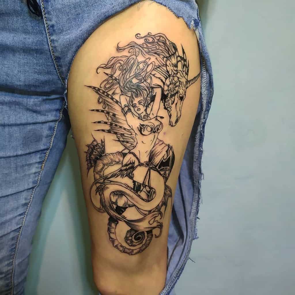 Intricate black and grey tattoo of a warrior mermaid with wings, flowing hair, and a serpentine tail, alongside a majestic unicorn.