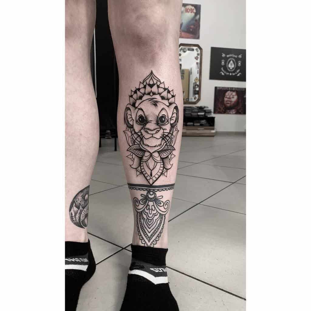 Intricate Simba tattoo surrounded by geometric and mandala patterns, symbolizing strength, wisdom, and growth