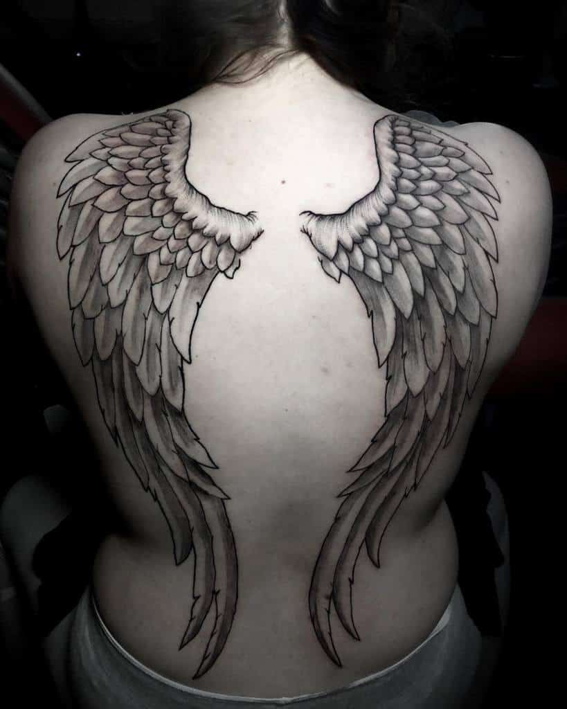 A large, detailed angel wing tattoos, featuring intricate feather designs in a realistic style