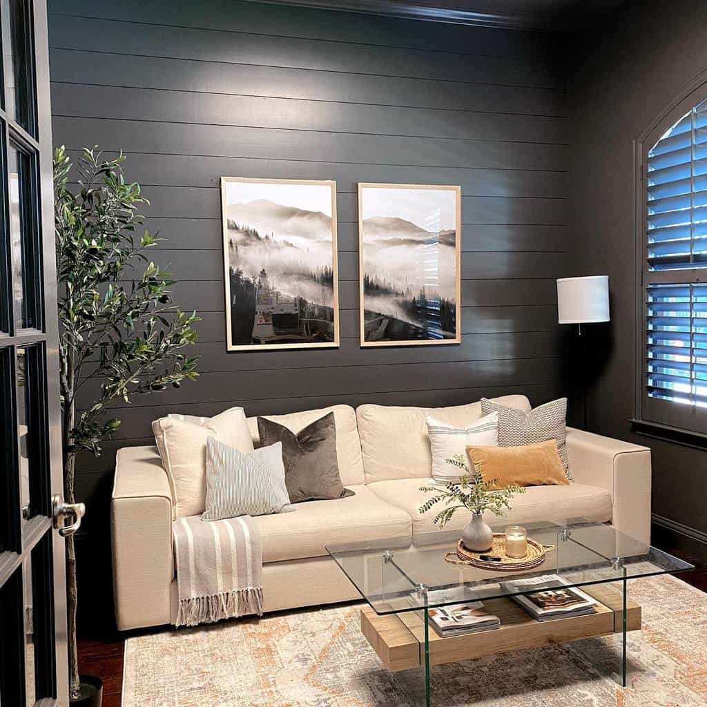 Modern living room with black accent wall, beige sofa, glass coffee table, and framed art.