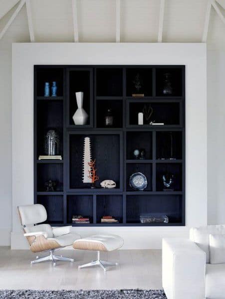 A sleek black built-in bookshelf with modern decorative items, vases, and sculptures, complementing a minimalist living space