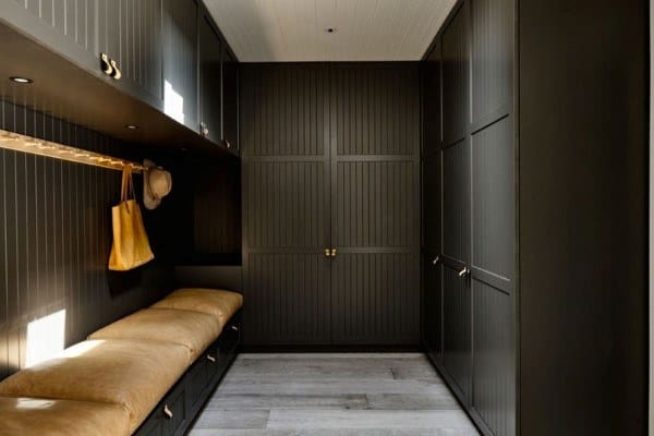 sleek modern mudroom with black cabinets and bench seating