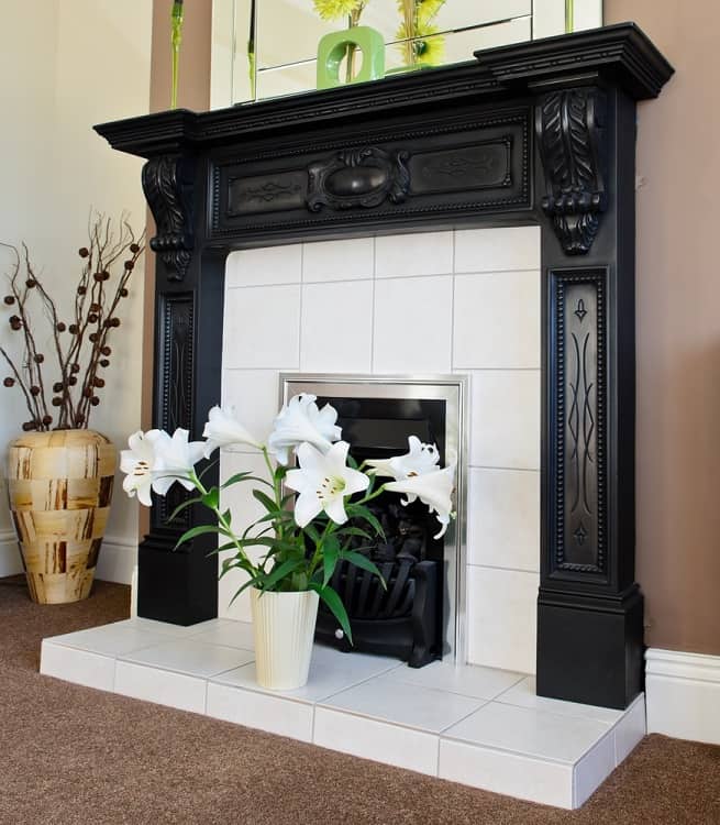 white tile fireplace with ornate black mantel
