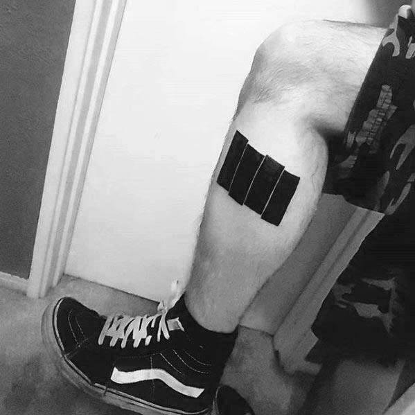 Bold Black Flag bars tattoo on the calf, angled across the muscle for a striking and rebellious punk-inspired statement.