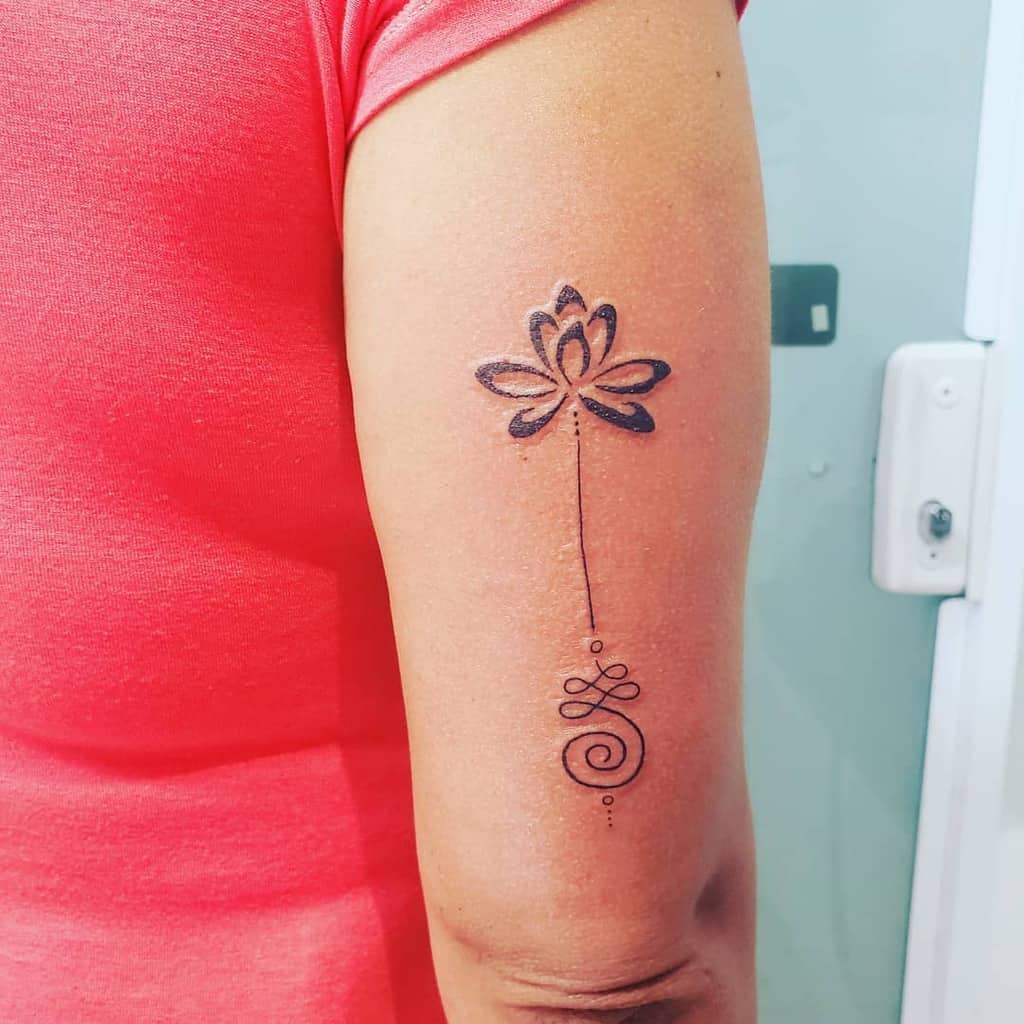 Unalome tattoo with a lotus on the upper arm, symbolizing spiritual growth, enlightenment, and the journey to inner peace.