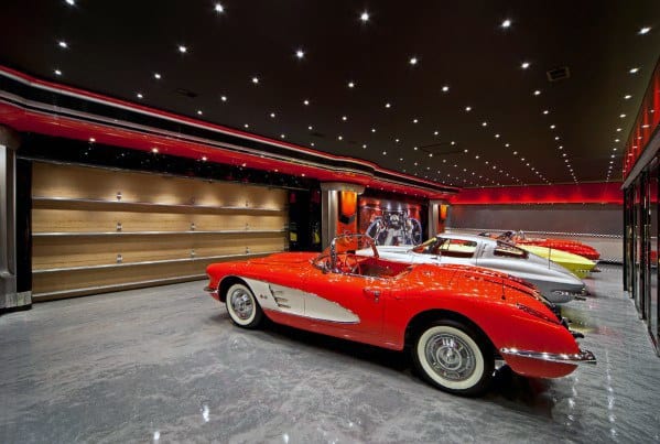 Luxury garage with glossy floors, recessed lighting, and classic red and white convertible cars.