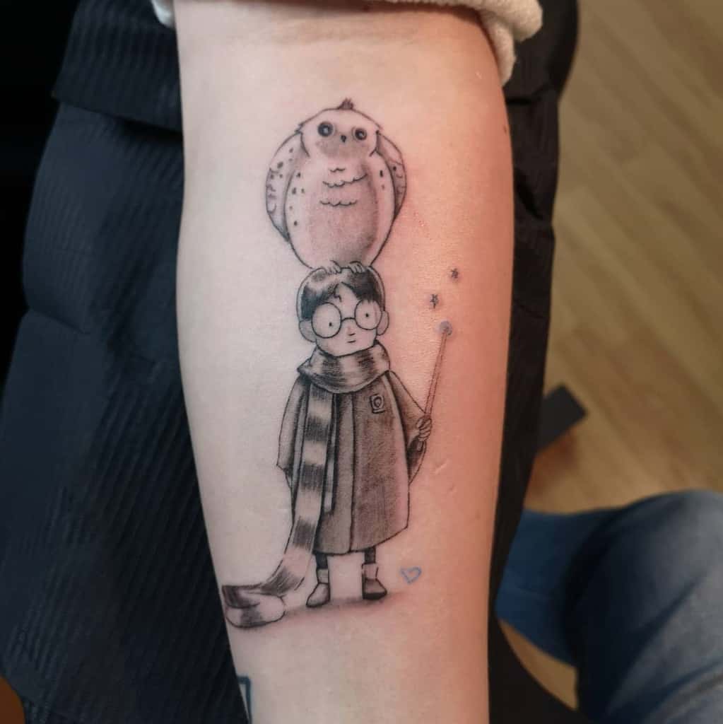 Adorable Harry Potter tattoo featuring a cute, minimalistic Harry with glasses, a wand, a long scarf, and Hedwig on his head.