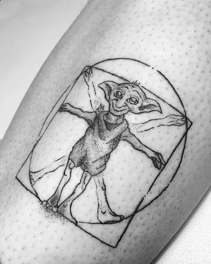 Creative tattoo of Dobby as the Vitruvian Man, blending Leonardo da Vinci’s iconic sketch with the beloved house-elf.
