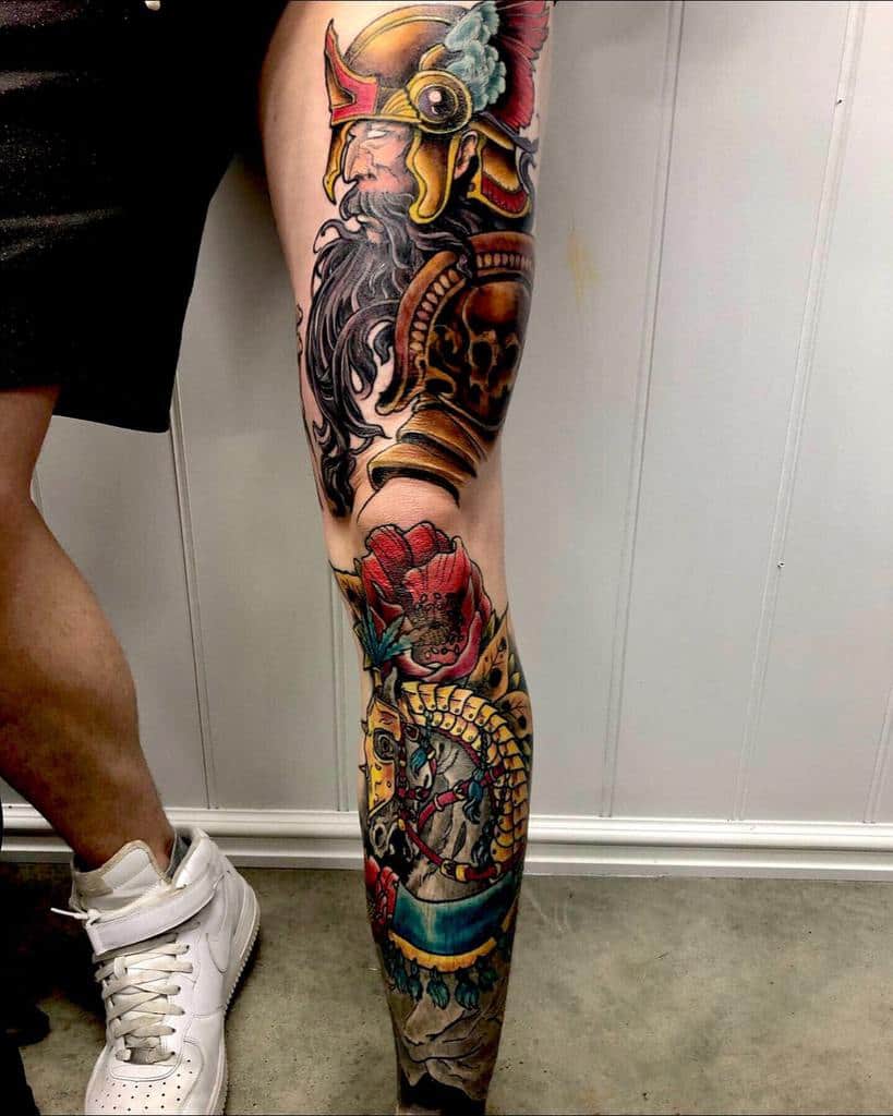 A leg sleeve tattoo featuring a colorful warrior helmet, skull, flower, and serpent design 