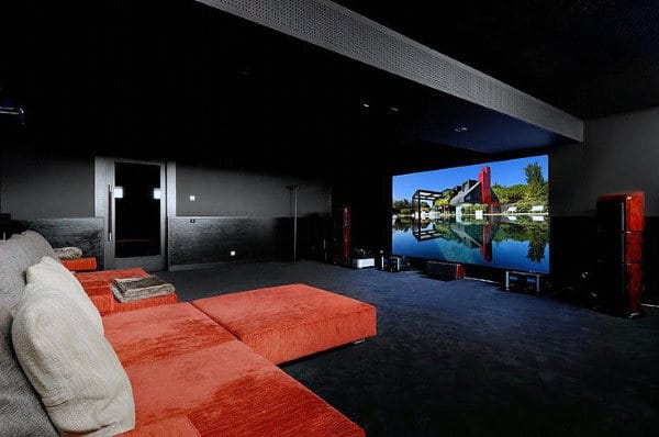 Red sectional sofa in home theater facing a large screen displaying a scenic landscape
