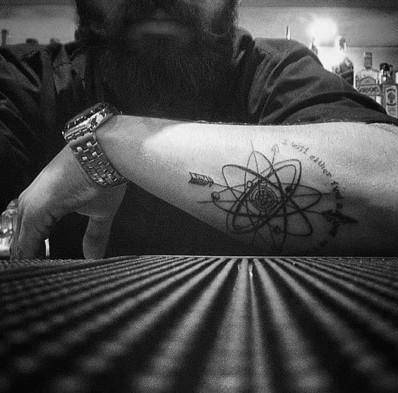 Black Ink Atom Out Of Forearm Tattoo On Man