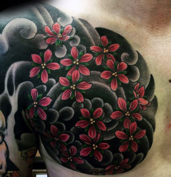 Chest tattoo featuring bold black and grey swirling clouds with vibrant red cherry blossoms, creating a striking Japanese-inspired design