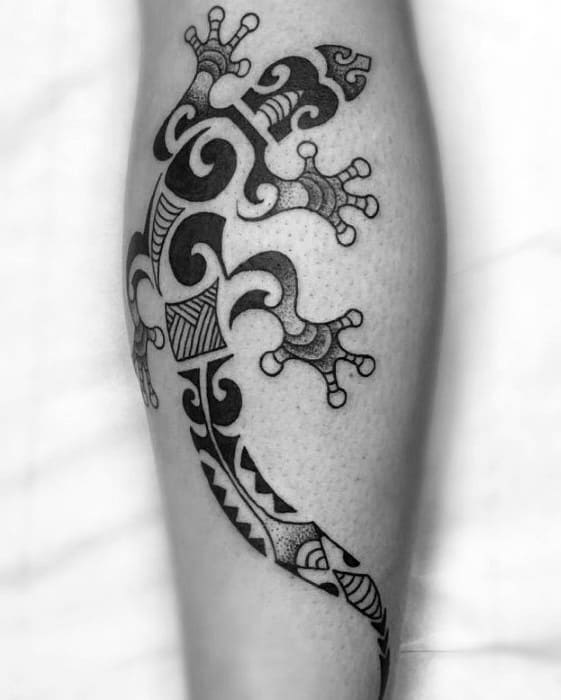 Black tribal gecko tattoo on calf with bold, intricate Polynesian-style patterns and curved geometric shapes.