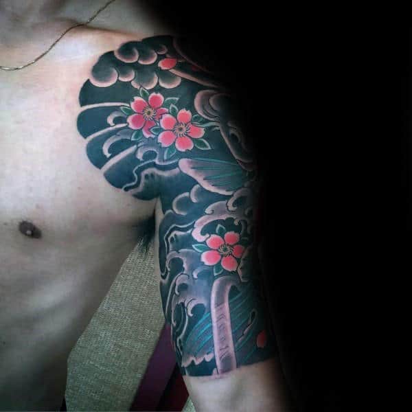 Japanese-style half-sleeve tattoo featuring a koi fish swimming through swirling waves, with vibrant pink cherry blossoms and intricate shading