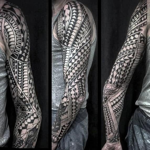 A person with a full sleeve tattoo in geometric tribal patterns