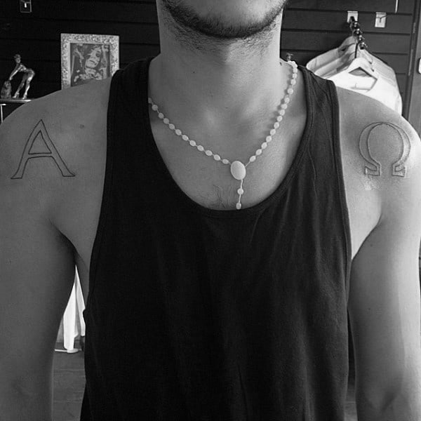 Black Ink Outline Alpha Omega Tattoo On Mans Shoulders