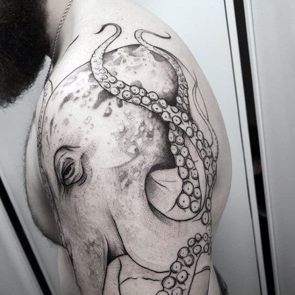 Tattoo of an octopus covering a man's upper arm and shoulder with visible tentacles