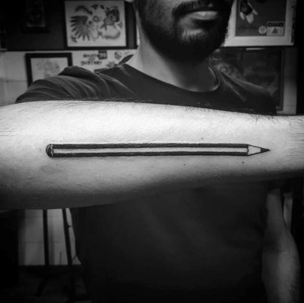 A stunning monochrome tattoo of a pencil elegantly stretches down the forearm, capturing the essence of artistry and precision