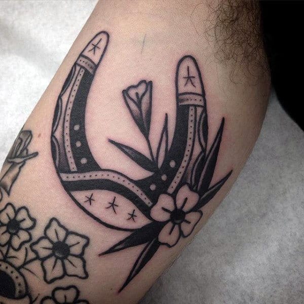 Black Ink Traditional Guys Horseshoe With Flower Tattoo Design On Bicep